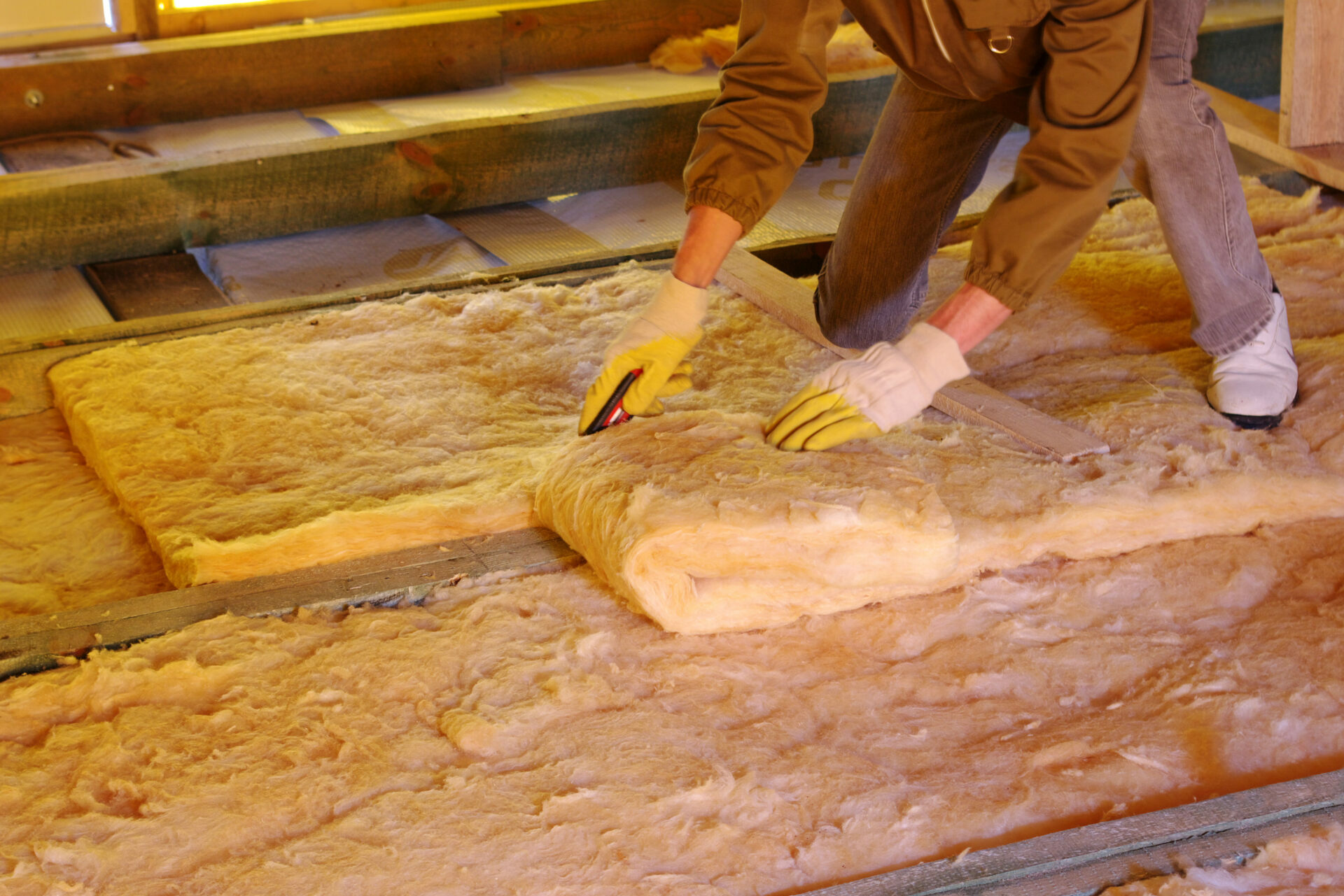 A NSW insulation installer cuts an insulation batt in a retrofit home.