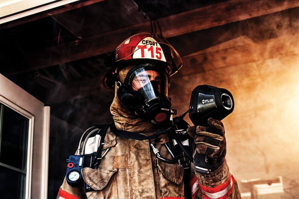 A firefighter uses a thermal imaging camera for search and rescue.
